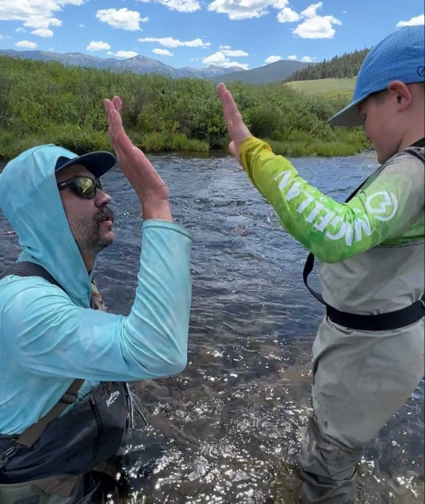 High five with kid while fly fishing