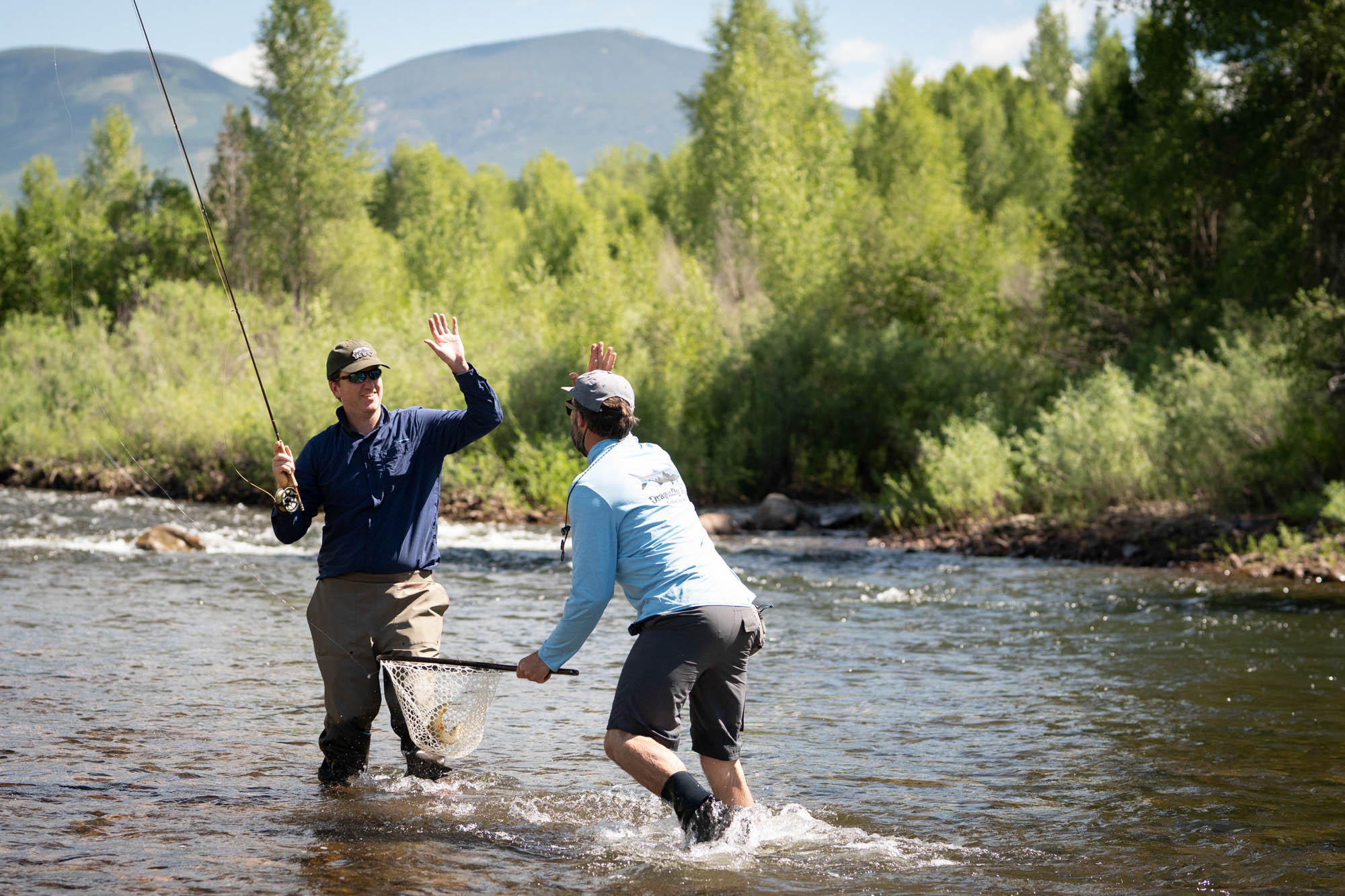 two men high five fly fishing east river crested butte