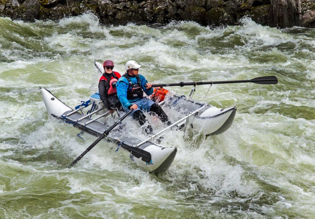 two people running whitewater in cataraft
