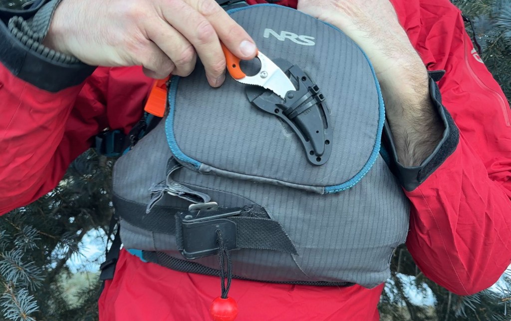 man holding CRKT River Knife on NRS PFD
