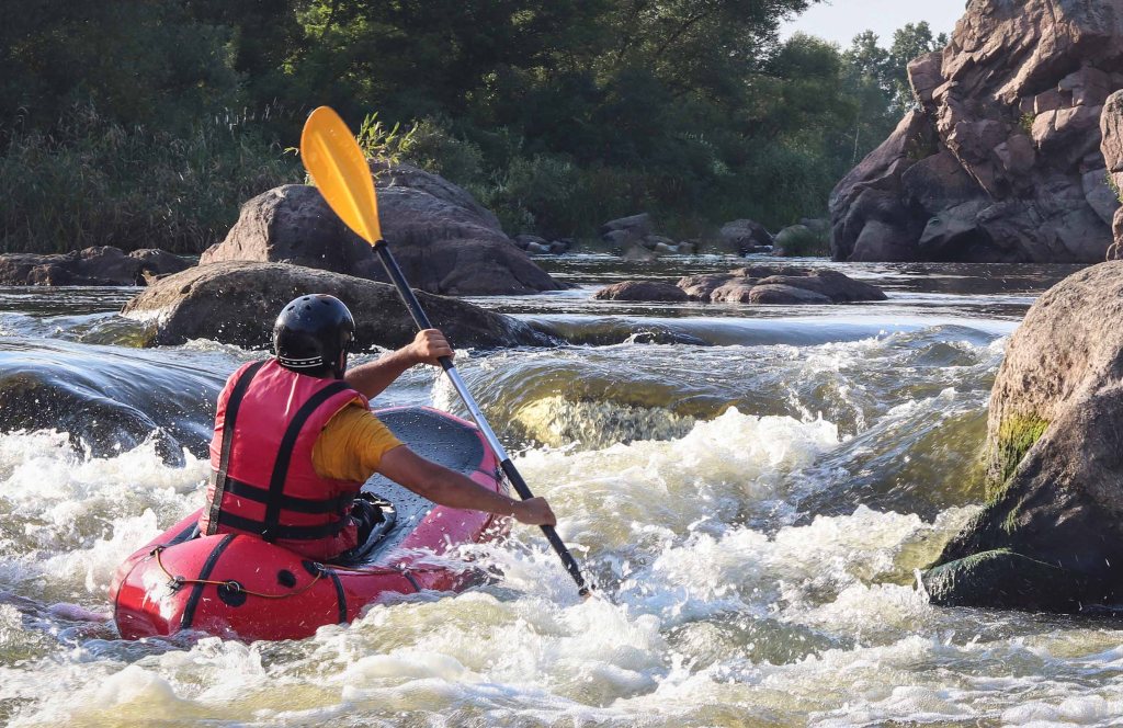 A man packrafting in a river.