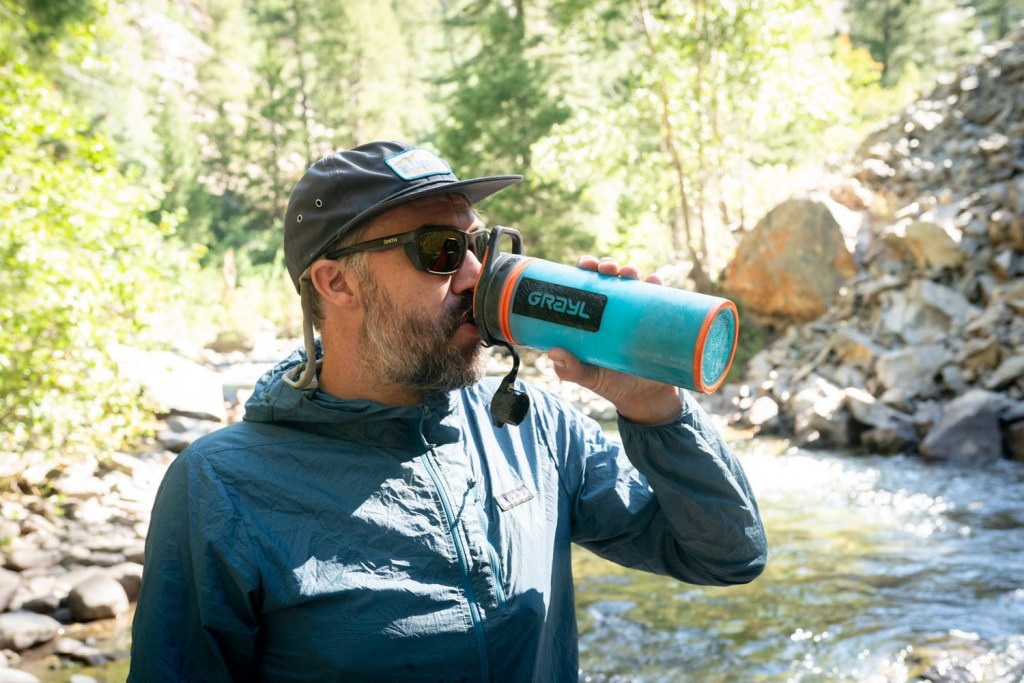 dan jones drinking grayl water bottle near river