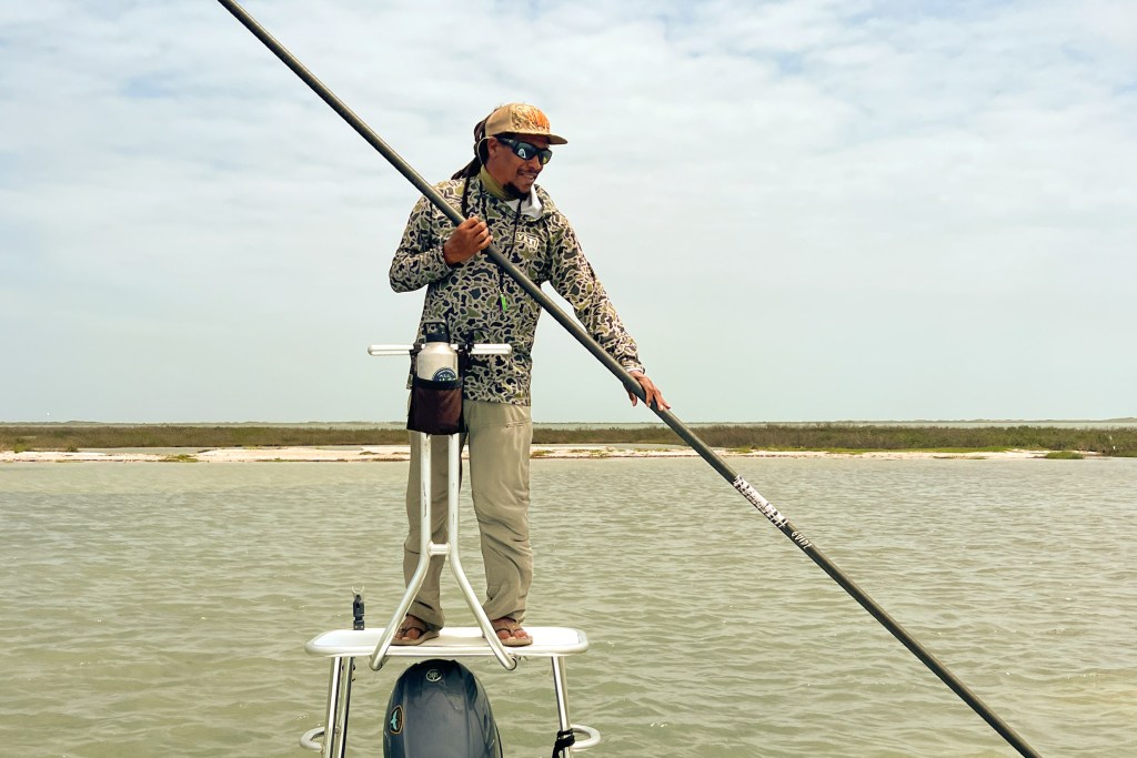 Alvin Dedeaux on a skiff guiding red fish fly fishing.
